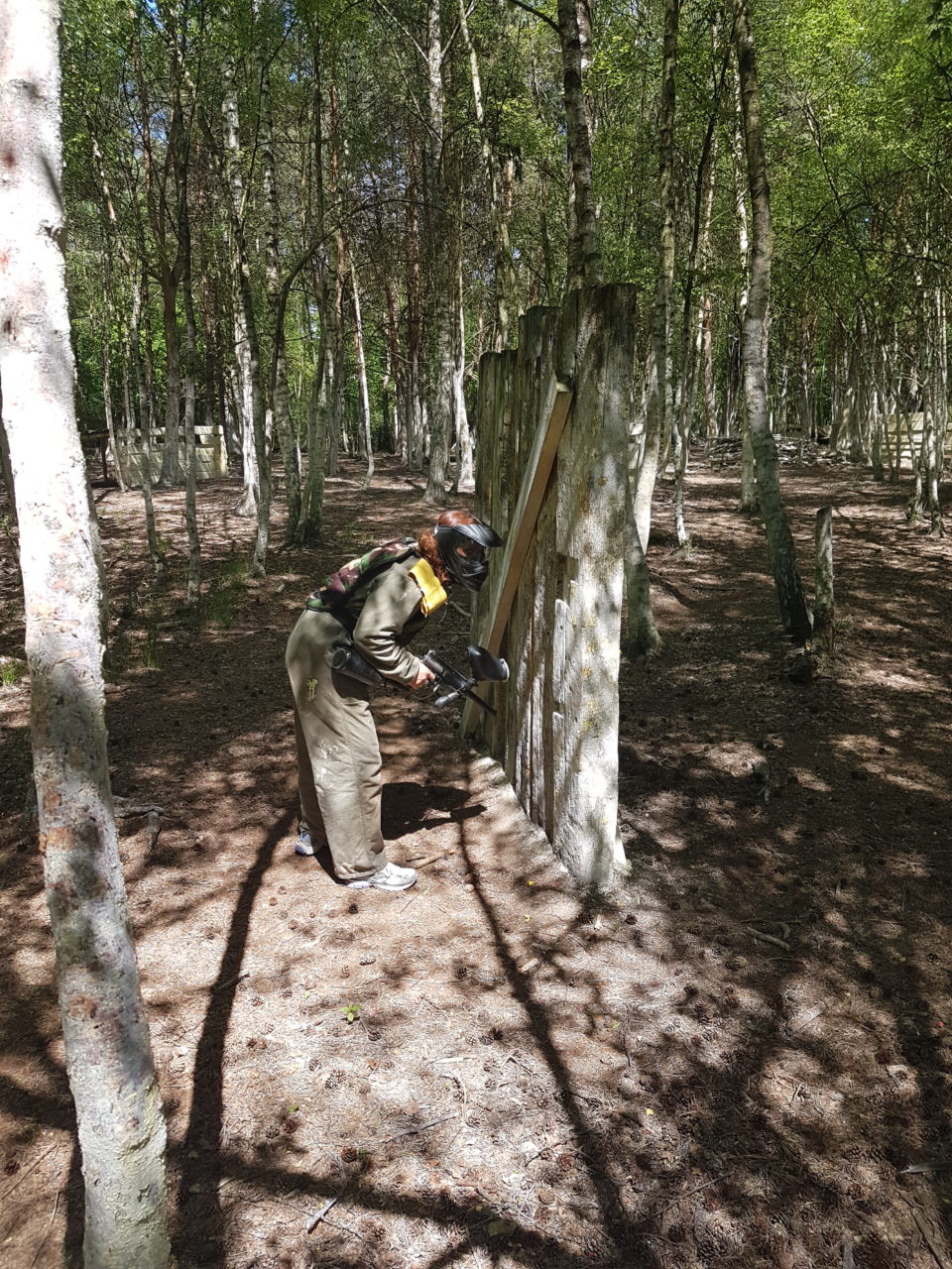 Paintball speelster zoekt dekking in het bos in Enschede