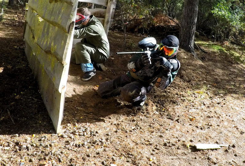 Paintball sportspeler schiet langs een bunker