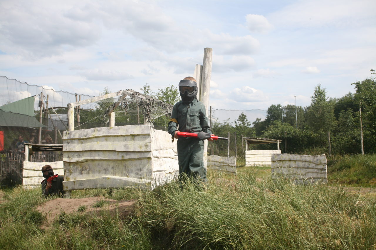 Jongen op heuvel kinderpaintball veld