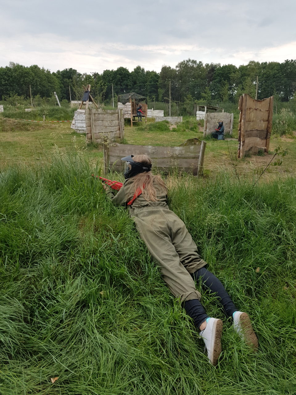 Meisje ligt op een heuvel kinderpaintball veld Enschede