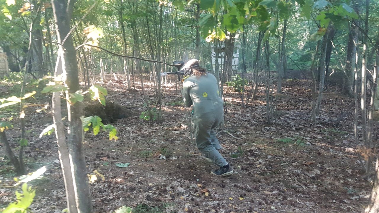 Paintball speelster rent door bos tijdens het paintball duel