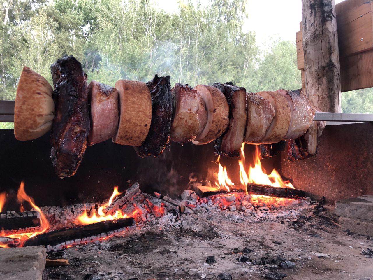 Diverse soorten vlees op spit boven houtvuur