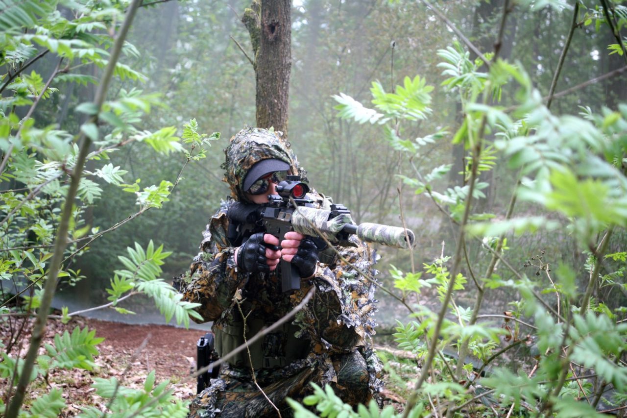 Airsoft speler verstopt zich in de bosjes